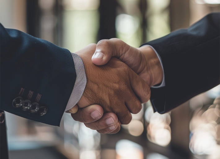 Two corporate lawyers shaking hands after completing a bridging loan.